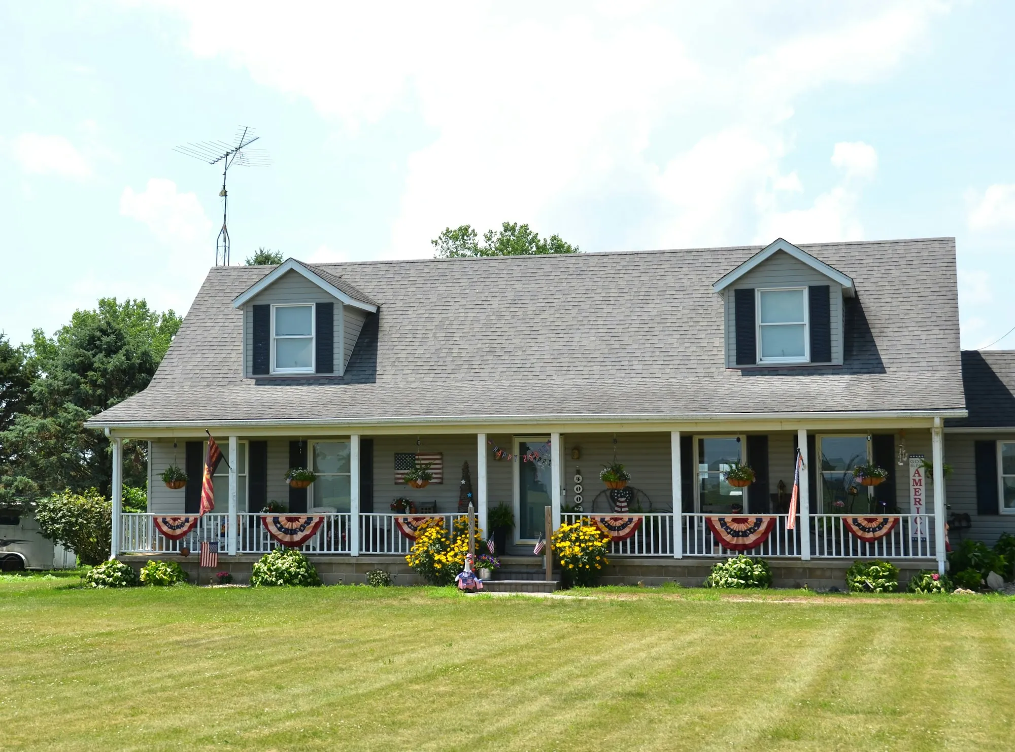Cape Cod home with dormers and patriotic bunting on the porch